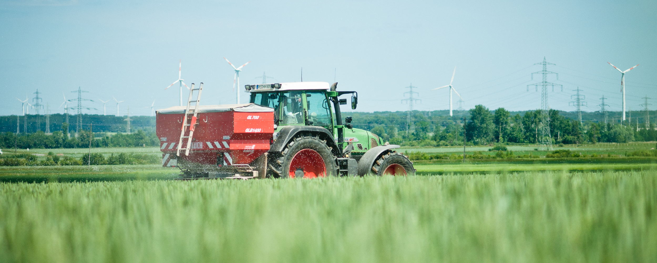 Ásványi trágya kijuttatása műtrágyaszóróval felszerelt traktorral.